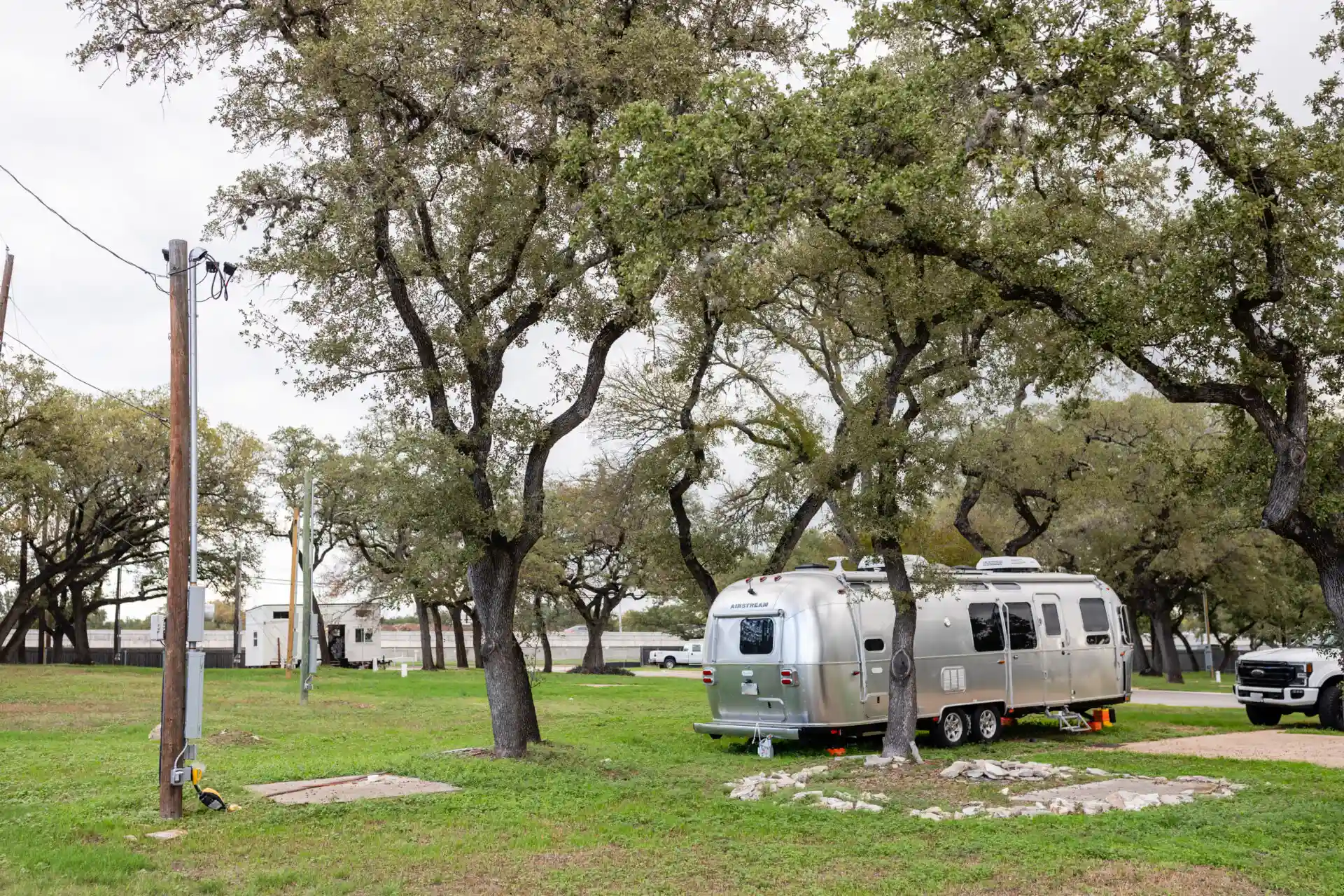 an RV Van in a part and trees around it